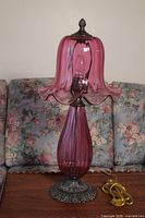 Front view of the lamp showing the cranberry glass body, matching shade and metal base.