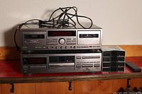 Two stacked JVC stereo equipment units: CD player model XL-M409 on top and tape deck model TD-W709 below, with cables on top and a remote to the side.