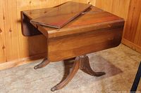 Side view of the vintage wooden drop leaf table showing one leaf extended and insert piece on top