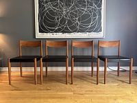 Front elevation of four chairs in a row under wall art showing overall condition