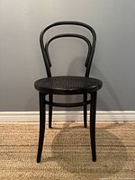 Front view of black bentwood chair showing curved backrest and legs