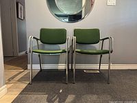 Two chairs front view showing chrome frames and green upholstery