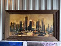 Framed vintage print "Skyline Horizon" depicting city skyline in warm tones with boats, showing entire framed artwork against wall.