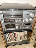Photo of the vintage multi-function audio unit showing turntable, radio tuner, cassette player and vinyl record storage below