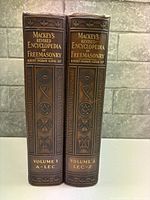 Two brown faux-leather volumes side by side showing gilt embossed spines