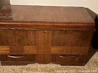 Closed view of the vintage Honderich cedar chest showing brown wood finish and drawer front.