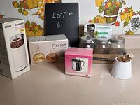 Photo showing all items in lot including Braun coffee grinder box, glass oil and vinegar set, mason jars in box, stainless creamer and honey jar with wooden dipper