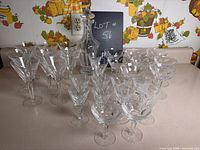 Photo showing the complete set of crystal glasses and decanter with matching stopper arranged on a flat surface with a decorative background.