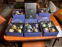 Seven open ornament boxes on table, each holding four ornaments