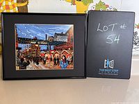Framed print of Toronto's Distillery District with black low profile frame, showing street, people, and festival lights.