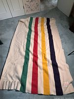 Blanket laid flat on floor showing full length and stripes