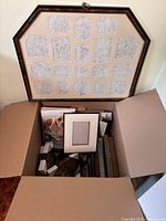 Photo of large display frame and box of assorted frames and photo albums