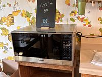 Panasonic microwave on wooden stand, showing front and side views