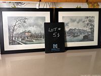 Photo showing both framed Paris prints with black frames and white mattes arranged side by side from a frontal angle.