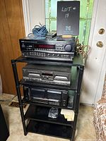 Overall view of the Denon receiver, Techniques tape deck, and Pioneer CD player stacked on a rack with cables and remote on top, showing front controls and display.