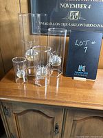 Photo showing all four glass oil candles of varying heights arranged on a wooden surface.