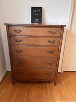 Front view showing five drawers with metal handles and visible surface wear.