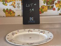 Oval ceramic serving platter with floral pattern and visible crazing viewed from above.