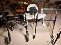 Photo showing two walkers side by side with white bath seat behind.