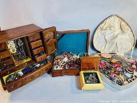 Full view of the jewelry lot including all storage boxes and scattered jewelry pieces
