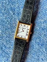 Close-up of watch face and upper strap on blue background