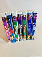 Seven sealed Walt Disney VHS tapes standing upright, showing spines with titles and Masterpiece Collection branding