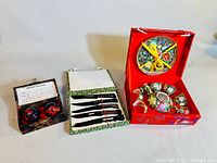 Full view of the three boxed Chinese gift sets: iron balls, ceramic cutters, and porcelain tea set with floral motifs