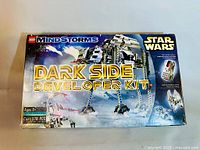 Photo showing the front of the LEGO Mindstorms Dark Side Developer Kit box with visible damage and box art depicting the Star Wars themed AT-ST model and Micro Scout.