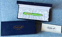 Pen displayed in open navy blue box with white satin lining and original printed materials.