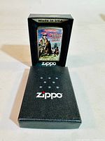 Black Zippo box containing Rough Rider image brass lighter, showing Made in USA text on the box insert.