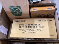 Photo showing three wooden boxes containing Carb-Tech and MLCS woodworking bits including the 16-piece Carb-Tech Forstner bit set labeled with sizes and made in China.