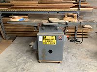 Full view of jointer with fence, push block, roll of tape and power cord