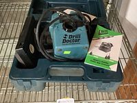 Drill Doctor Model 500 drill bit sharpener with hard plastic carrying case and user manual inside the case.