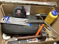 Overview of lot showing tape measures, T-Bevel, scribers, and other tools inside a cardboard box.
