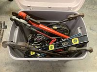 Photo of a box filled with pipe wrenches and two different bubble levels for plumbing work