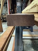 Side view of the board showing thickness and straight edge profile in workshop environment.