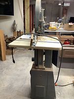 Front view of band saw including table, blade and integrated stand
