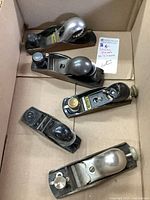 Top-down view of all five Stanley hand planes in a cardboard box showing mixed sizes and conditions.