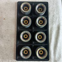 Eight Carrera 95A skateboard wheels arranged in two columns of four on a black plastic tray (tray not included with lot). Wheels show the black core and visible yellow bearings.