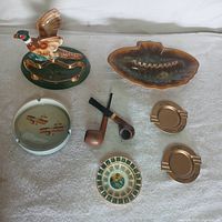 All included ash trays, tobacco pipes and tobacco tin shown together on surface