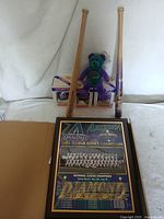 Lot overview showing two miniature bats, plush bear, boxed ornaments, and framed plaque