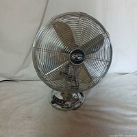 Front view of a silver Hampton Bay desk fan showing the four-blade propeller and protective metal mesh cage.