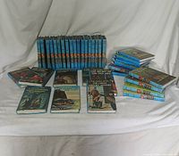 Full lot of 36 Hardy Boys books arranged showing spines and front covers.