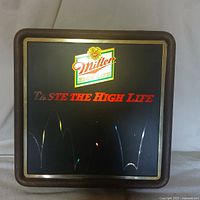 Front view of illuminated Miller High Life bar sign with logo and slogan "Taste the High Life".