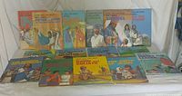 Collection of 15 Now You Can Read Bible Stories books laid out in two rows on a white cloth background
