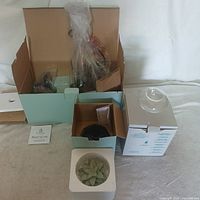 Opened boxes showing new PartyLite Windsor Taper Sconce pair and accessories including decorative wax items.