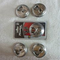Five Master Lock stainless steel disc padlocks. Four are loose and one is new in its original packaging.