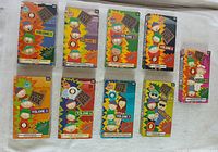 Set of nine South Park VHS tapes with original colorful cardboard sleeves displayed on white fabric surface.