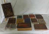 Wide shot showing 14 vintage books arranged on a cloth surface