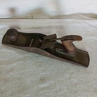 Full view of the vintage wood hand plane showing the body, wooden handle, and front knob.